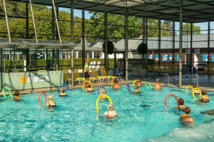 Badegäste mit Schwimmnudel nehmen am Aqua-Power-Kurs teil