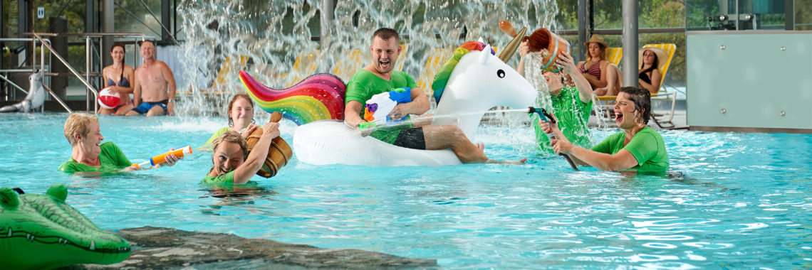 Mitarbeiter im Nichtschwimmerbecken bespritzen sich gegenseitig mit Wasser