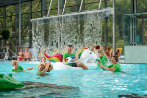 Mitarbeiter im Nichtschwimmerbecken bespritzen sich gegenseitig mit Wasser
