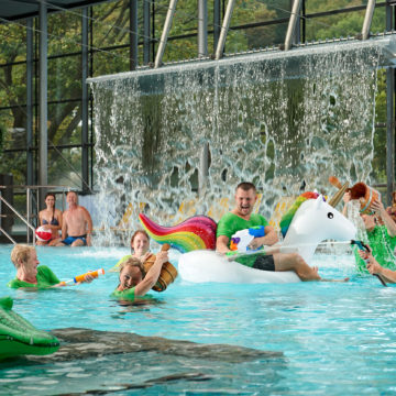 Mitarbeiter im Nichtschwimmerbecken bespritzen sich gegenseitig mit Wasser