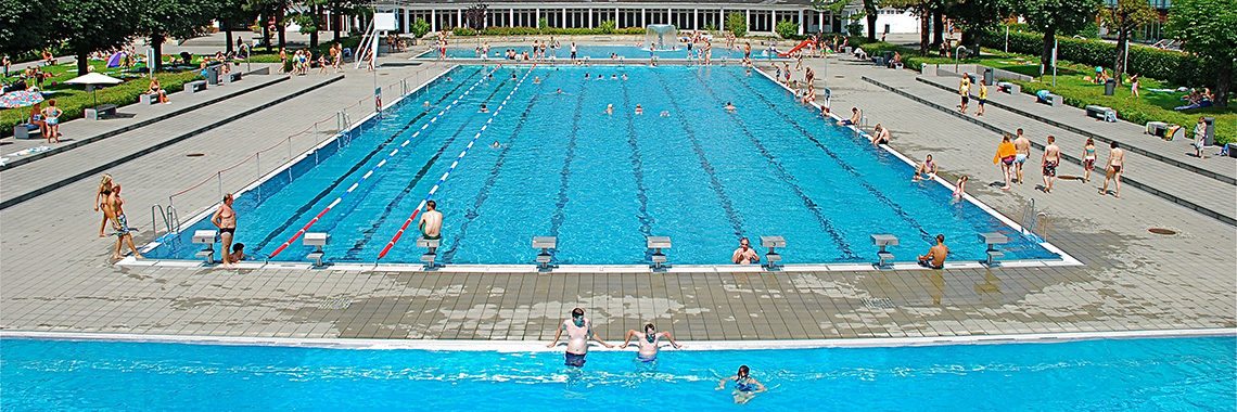 Großes Schwimmerbecken und viele Badegäste im Freibad