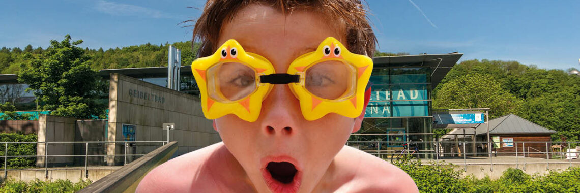 Junge mit Schwimmbrille vor dem Geibeltbad