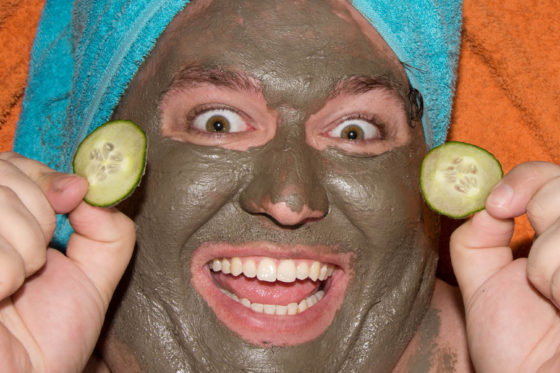 Mann mit Gesichtsmaske und Gurkenscheiben