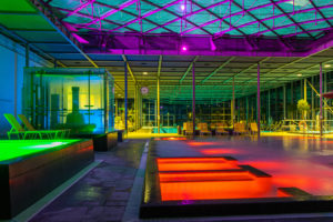 Farbenfrohe Beleuchtung im abendlichen Hallenbad