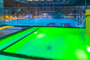 Grüne Unterwasserbeleuchtung im abendlichen Hallenbad